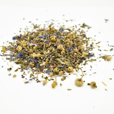 Dreamscape Loose Leaf Tea 🌙—a caffeine-free blend of chamomile and blue cornflowers—spilled loosely across a white surface.